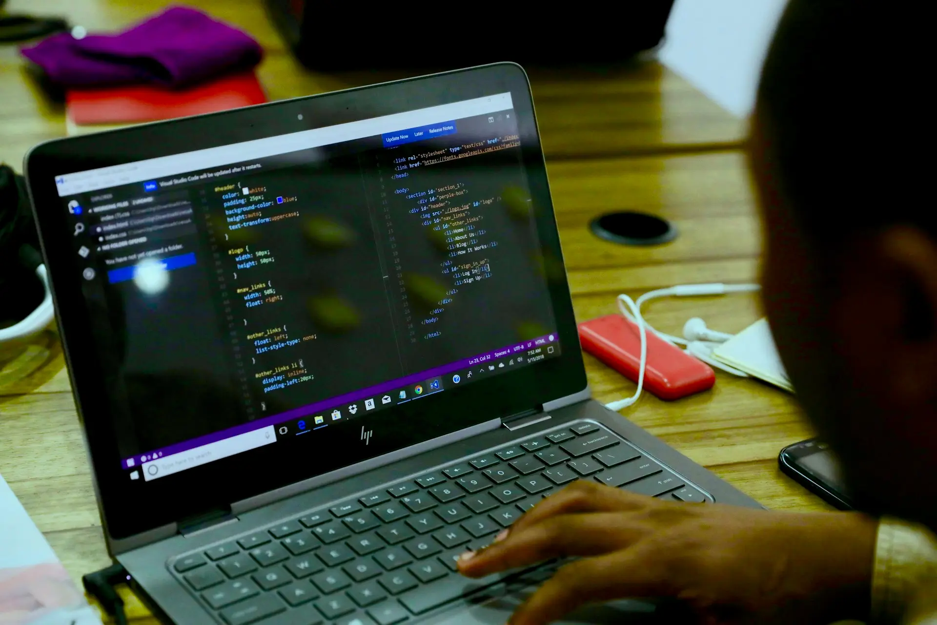 Hands at a keyboard with code on the display